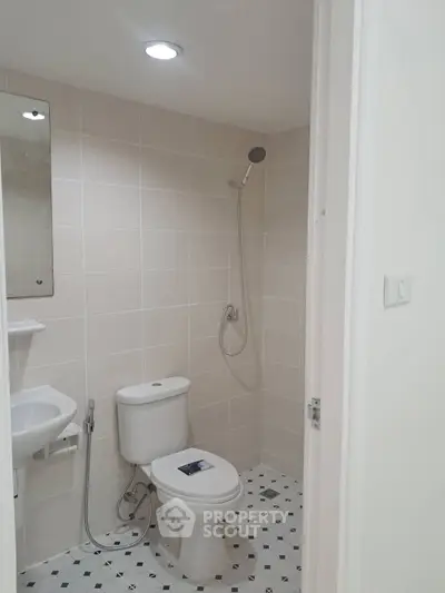 Modern bathroom with shower and toilet in a minimalist design.