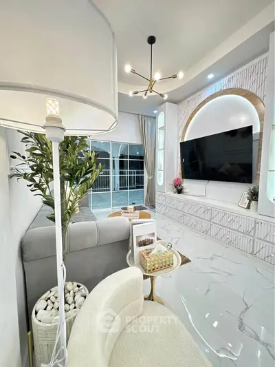 Luxurious modern living room with elegant decor and large TV, featuring sleek marble flooring and stylish lighting.