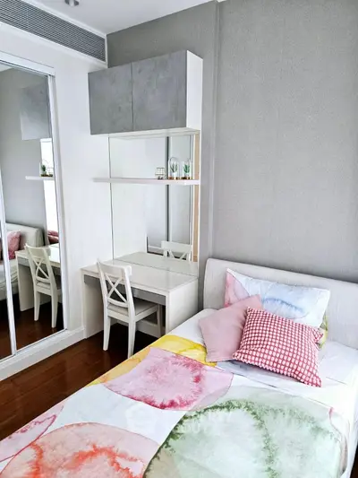 Chic modern bedroom with colorful bedding and mirrored closet in a stylish apartment.