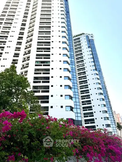 Stunning high-rise residential buildings with lush floral foreground, showcasing modern urban living.