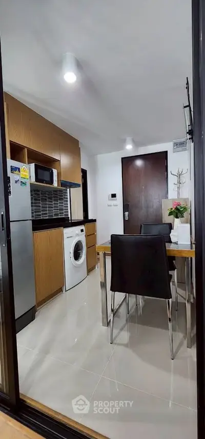 Modern kitchen with sleek appliances and dining area in a stylish apartment.