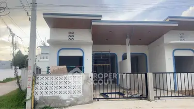 Modern single-story house with sleek design and spacious front yard, featuring a minimalist facade and gated entrance.