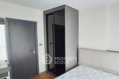 Modern bedroom with sleek wardrobe and comfortable bed in stylish apartment.