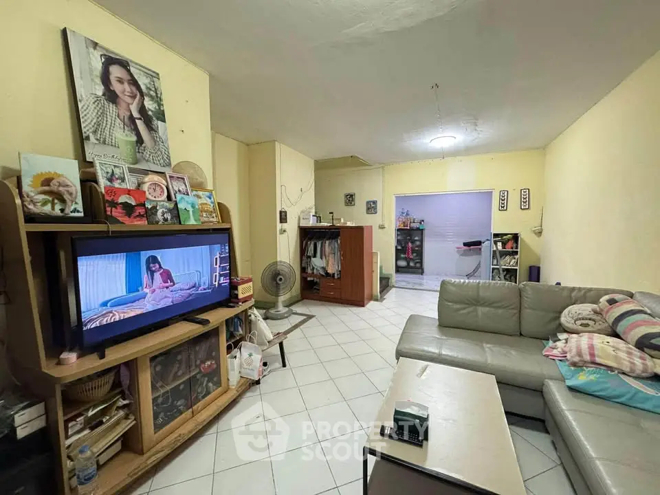 Cozy living room with modern TV setup and comfortable seating in a well-lit space.