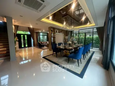 Luxurious open-plan living and dining area with elegant decor and large windows.