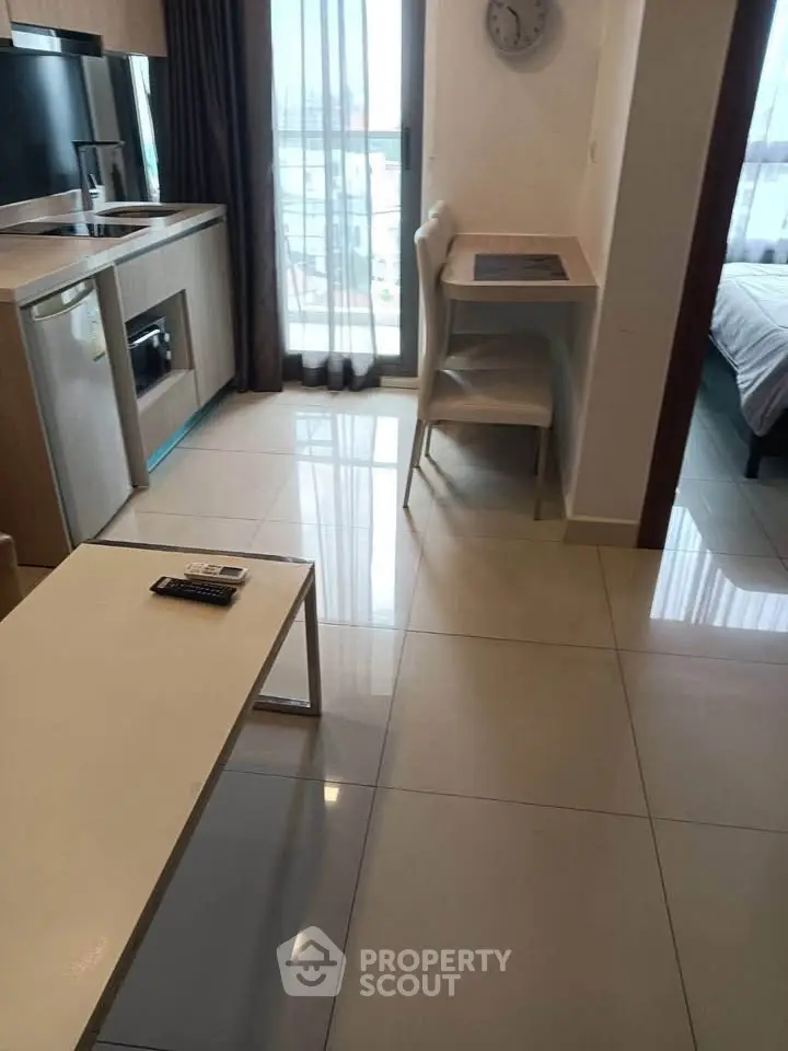 Modern studio apartment with compact kitchen and cozy living area, perfect for urban living.