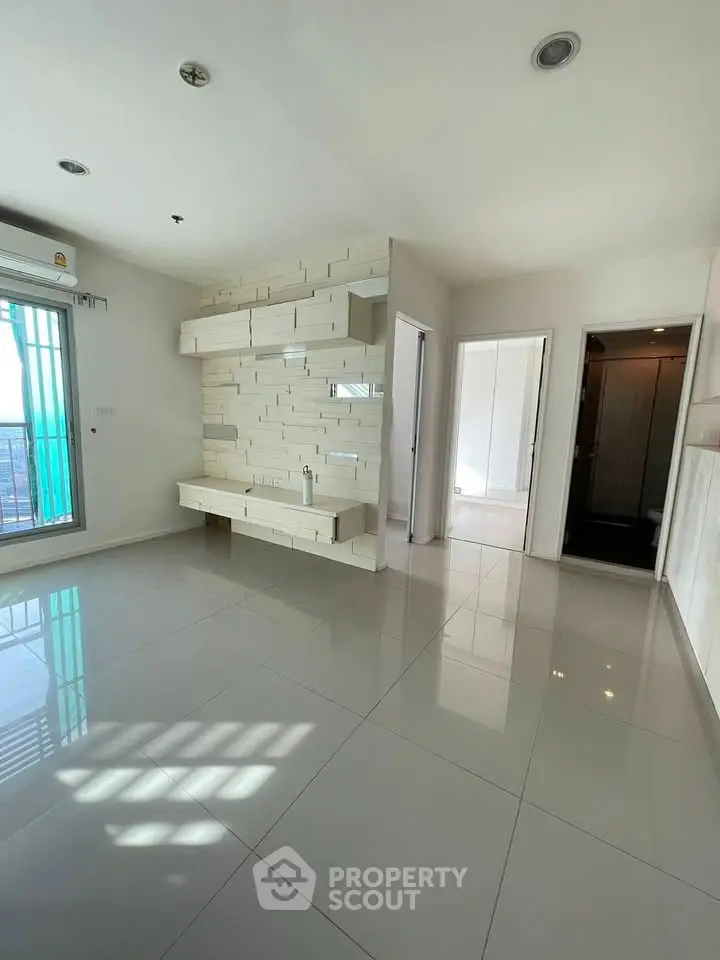 Spacious modern living room with sleek tile flooring and unique wall design in a bright apartment.