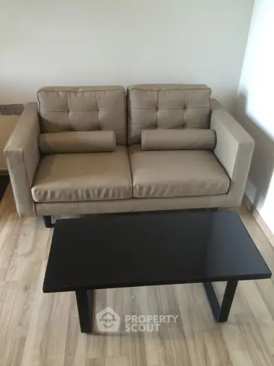 Modern beige sofa with sleek black coffee table on wooden floor