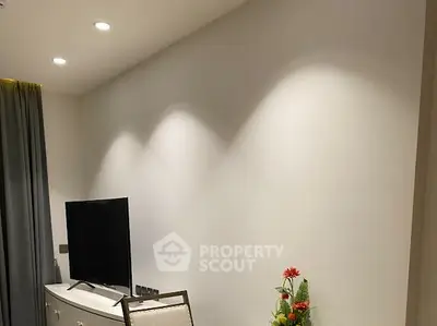 Modern living room with TV and elegant lighting, perfect for cozy evenings.