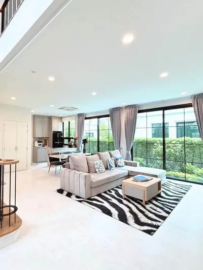 Spacious modern living room with large windows and elegant decor in a luxury home.