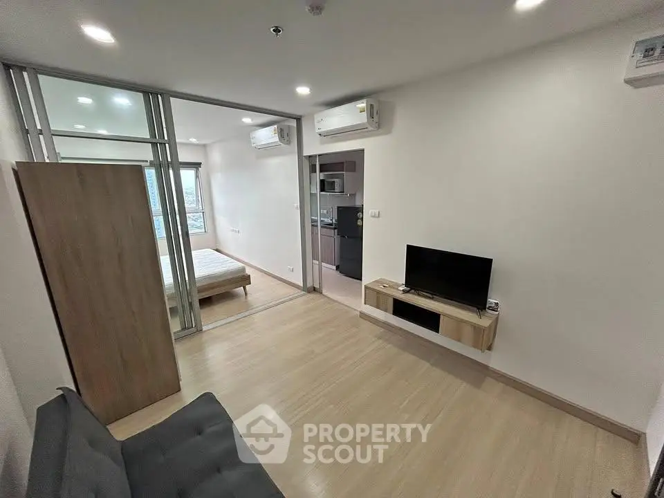 Modern living room with wooden flooring and sleek furniture in a stylish apartment.
