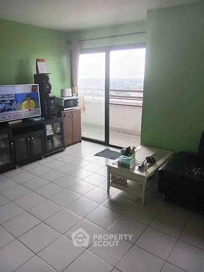 Spacious living room with balcony access and city view, perfect for relaxation and entertainment.