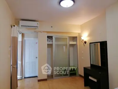 Spacious bedroom with modern closet and air conditioning in a cozy apartment.