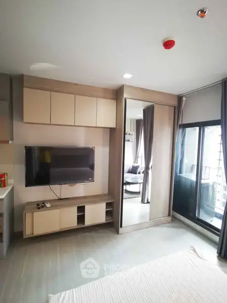 Modern living room with sleek TV setup and balcony access