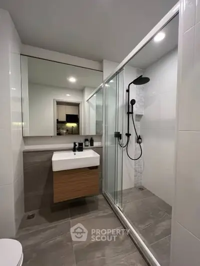 Modern bathroom with sleek shower and stylish vanity in contemporary apartment.