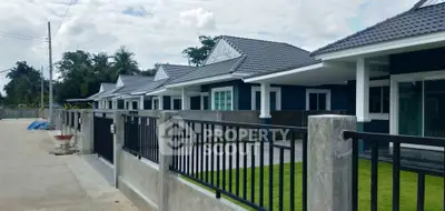 Charming row of modern single-story homes with sleek fences and lush green lawns.