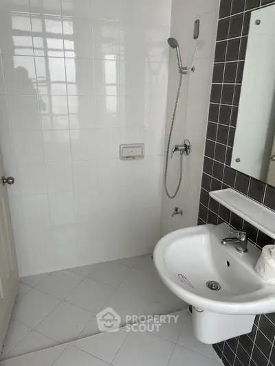 Modern bathroom with sleek black and white tiles and contemporary fixtures.