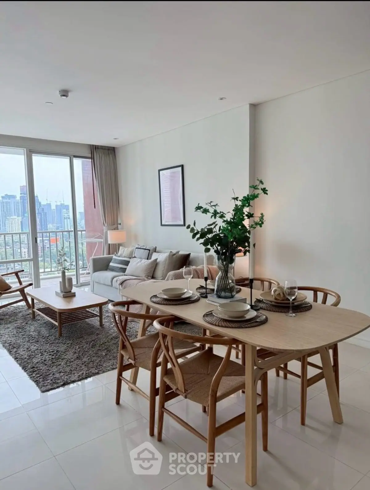 Modern open-plan living and dining area with city view, featuring stylish furniture and elegant decor.