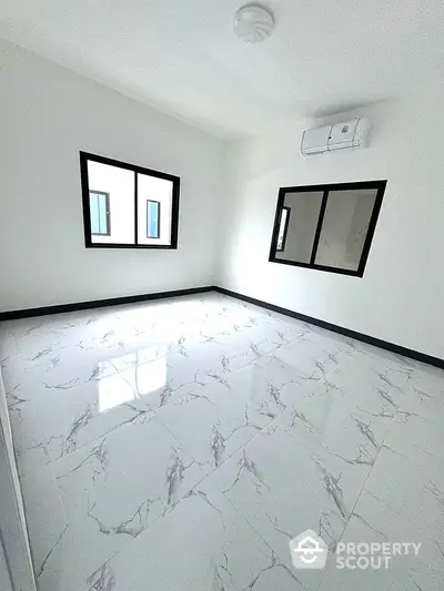 Spacious empty room with marble flooring and large windows in modern apartment