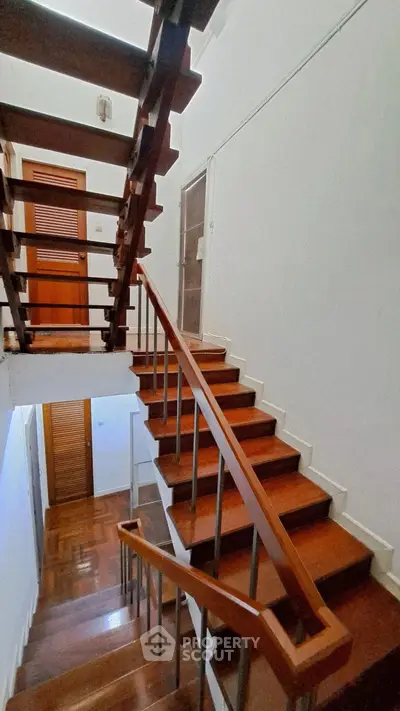 Elegant wooden staircase with modern railing in a stylish home interior