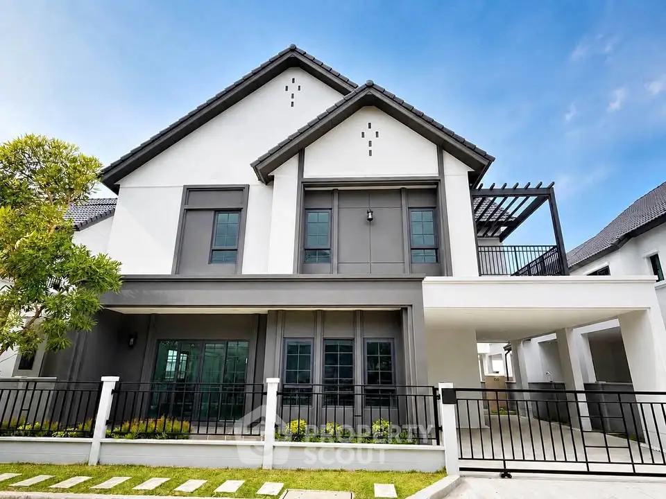 Modern two-story house with sleek design and spacious balcony, perfect for family living.