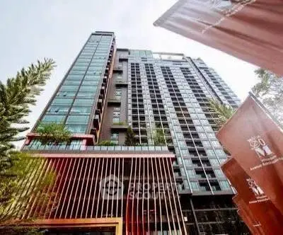 Modern high-rise building with sleek architectural design and lush greenery.