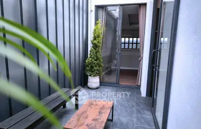 Chic modern balcony with stylish seating and potted plant, perfect for relaxation.