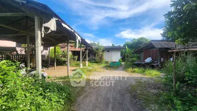 Charming rustic property with multiple structures and lush greenery, ideal for renovation or development.