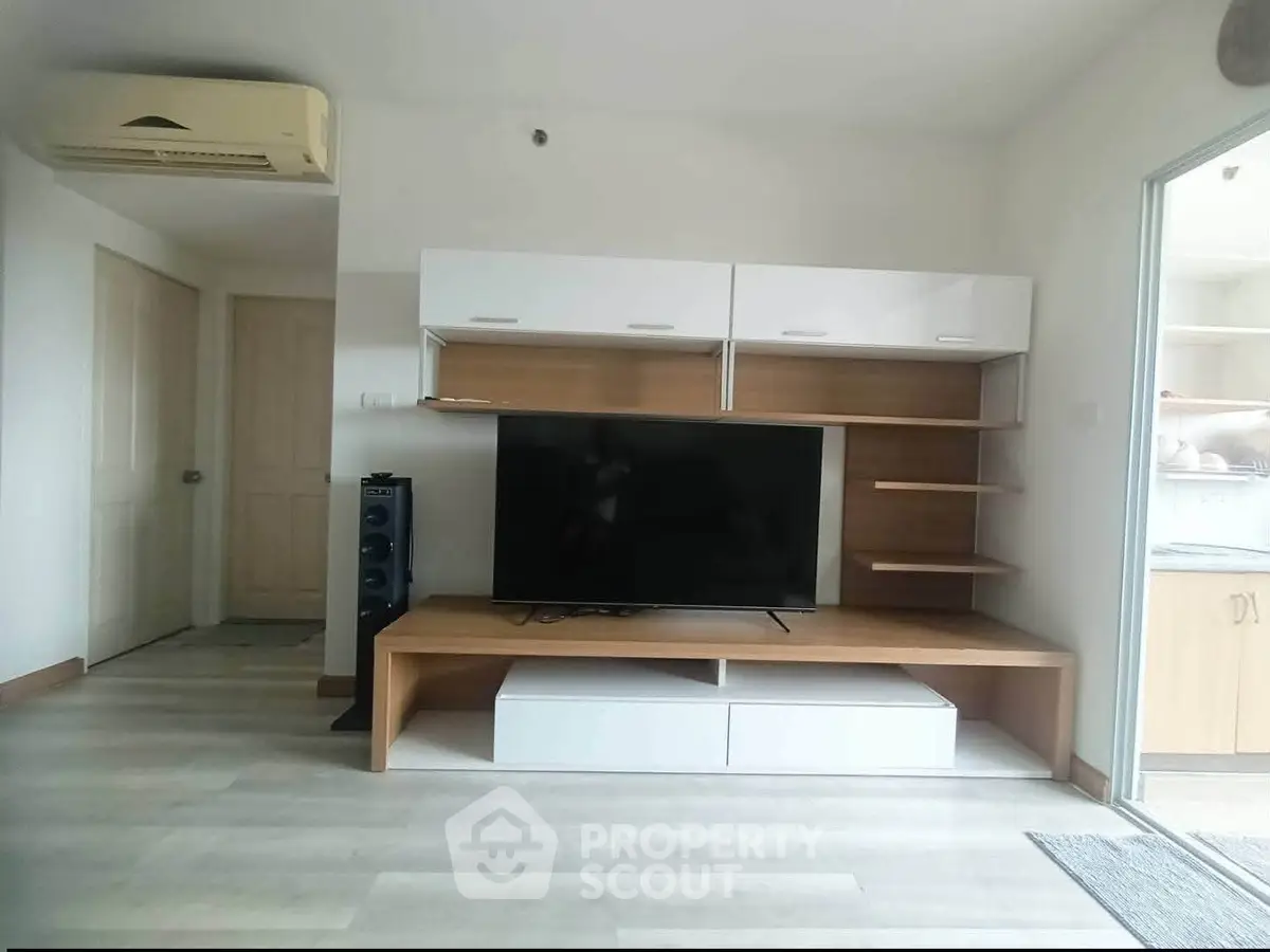 Modern living room with sleek TV unit and air conditioning, showcasing contemporary design and comfort.