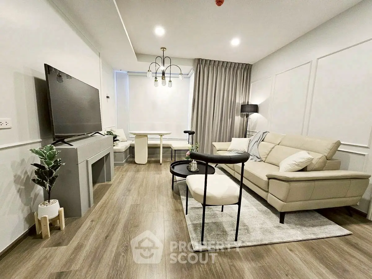 Modern living room with stylish furniture and large TV, perfect for relaxation and entertainment.