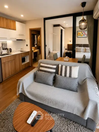 Modern open-plan living room with cozy sofa and stylish kitchen in a contemporary apartment.