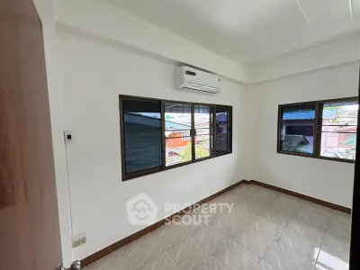 Bright empty room with large windows and air conditioning, ideal for customization.