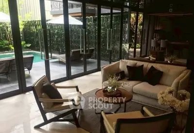 Luxurious living room with pool view and elegant furniture, perfect for relaxation and entertaining.