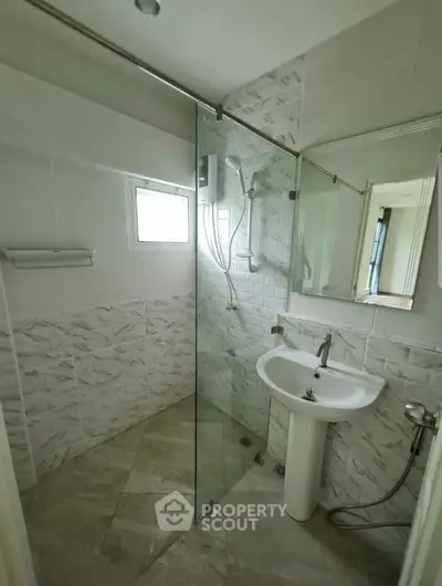 Modern bathroom with glass shower and sleek white sink