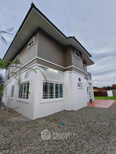 Modern two-story house with sleek design and spacious outdoor area.