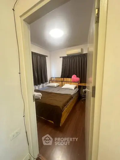 Cozy bedroom with wooden flooring and modern furnishings, perfect for relaxation.