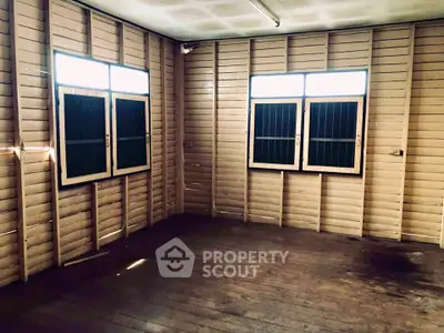 Spacious wooden interior room with natural light from large windows, ideal for creative renovation.