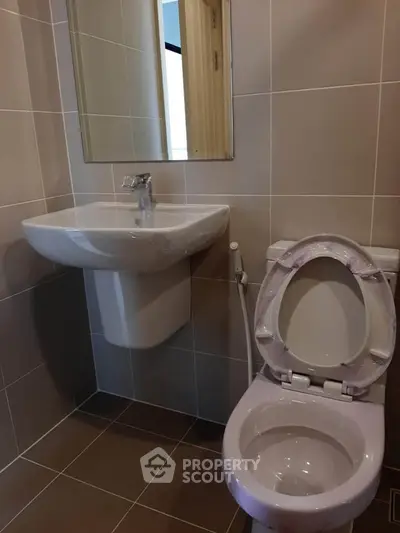 Modern bathroom with sleek sink and toilet in a compact space.