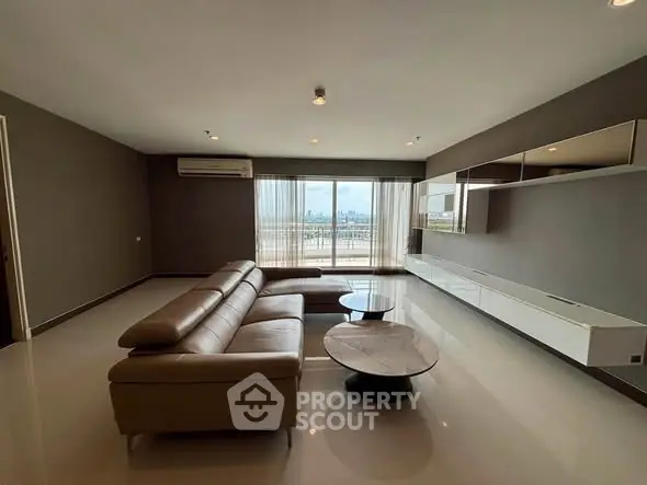 Spacious modern living room with sleek furniture and city view balcony.