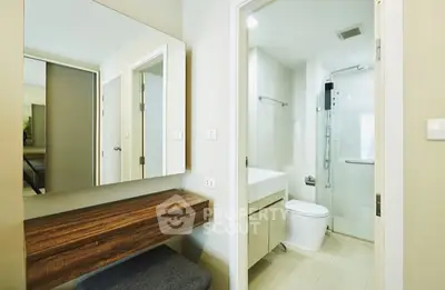 Modern bathroom with sleek design and wooden vanity in a contemporary apartment.