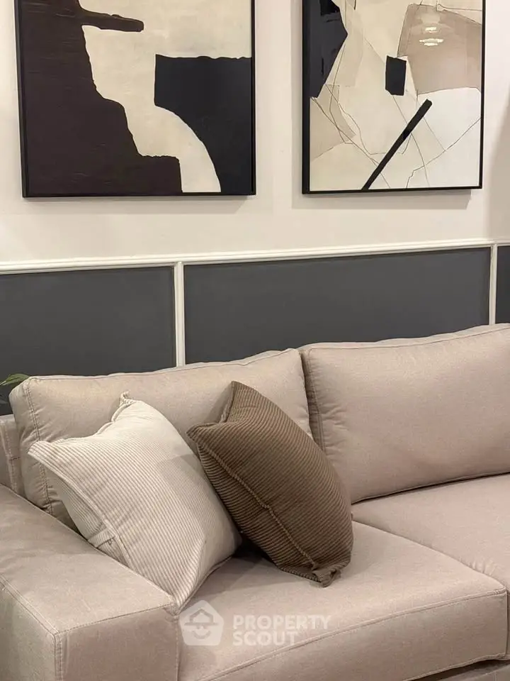 Modern living room with stylish abstract art and cozy beige sofa, perfect for contemporary home decor.