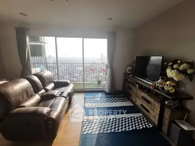 Spacious living room with leather sofa and city view balcony