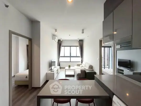 Modern open-plan living room with sleek kitchen and cozy seating area, perfect for urban living.