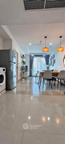 Modern open-plan living room with dining area, stylish lighting, and sleek appliances.