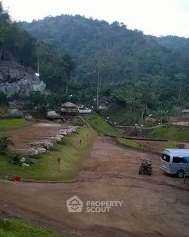 Scenic view of a rural property with lush greenery and mountainous backdrop, ideal for nature lovers.