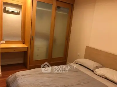 Cozy bedroom with wooden wardrobe and vanity, perfect for relaxation.