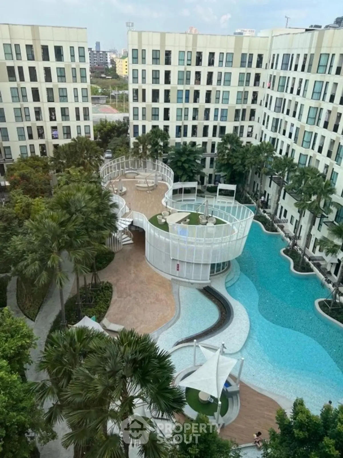 Luxurious apartment complex with stunning pool and modern architecture.