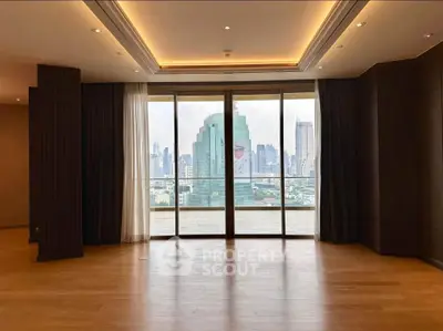 Spacious living room with floor-to-ceiling windows offering stunning city skyline views.