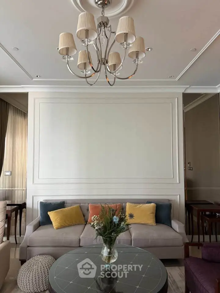 Elegant living room with plush sofa, stylish chandelier, and chic decor accents.
