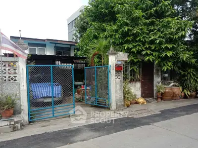 Charming residential property with gated entrance and lush greenery